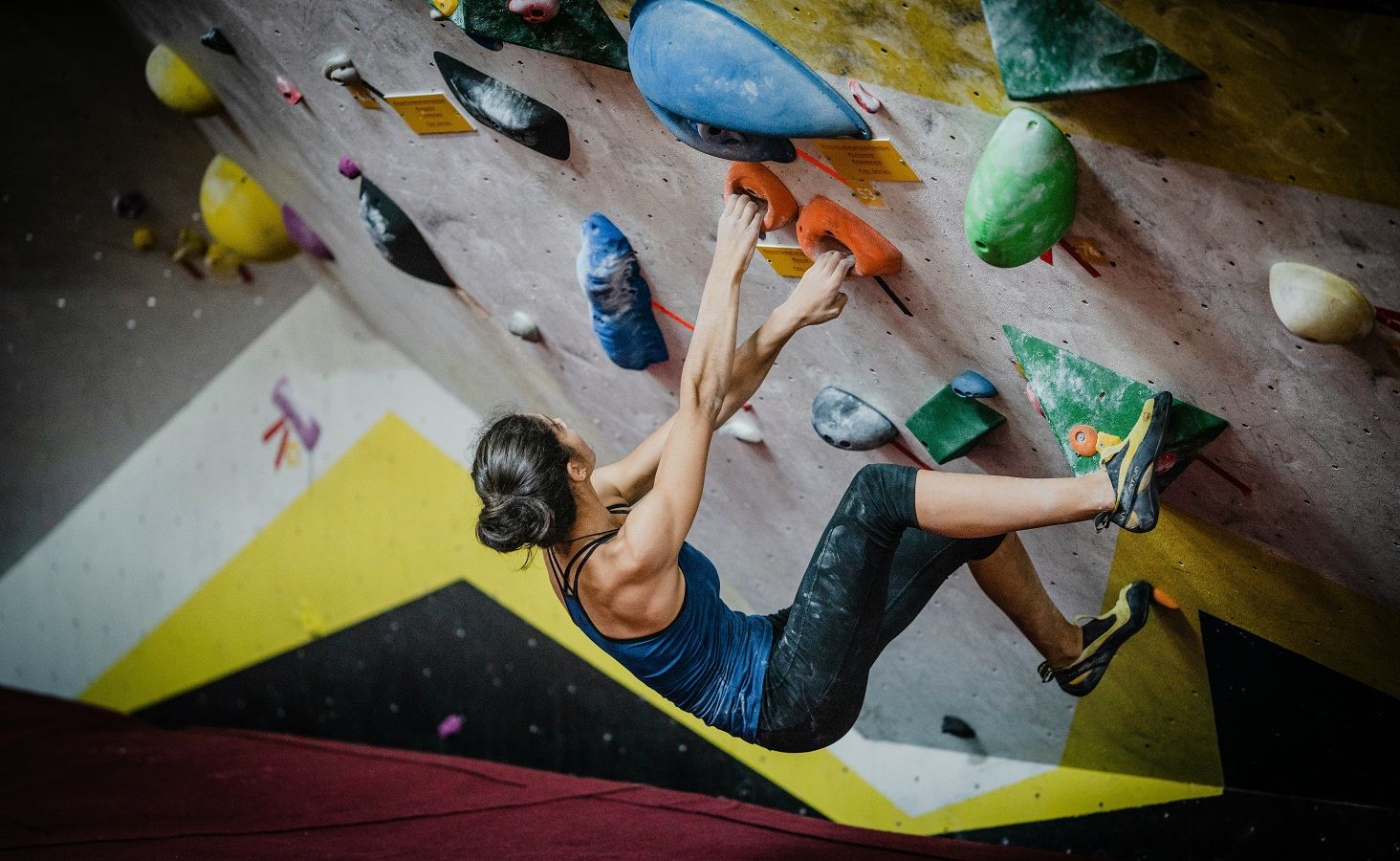Mujer escalando en un rocódromo