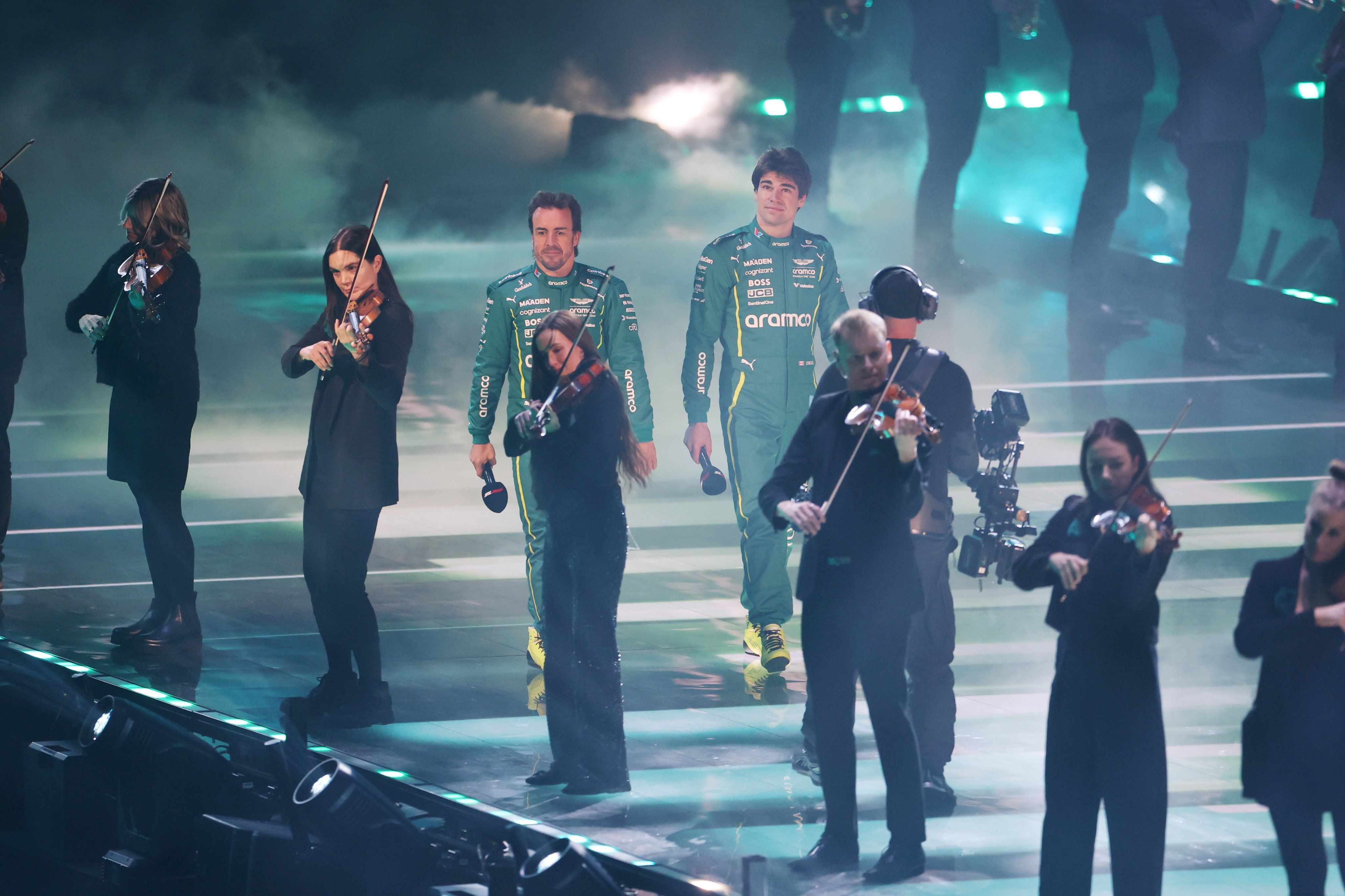 Aston Martin también sorprendió al público con un vídeo en el que sus pilotos emulaban a James Bond y llegaban al escenario en plena actuación musical de la artista Tems y dos filas de personas tocando el violín